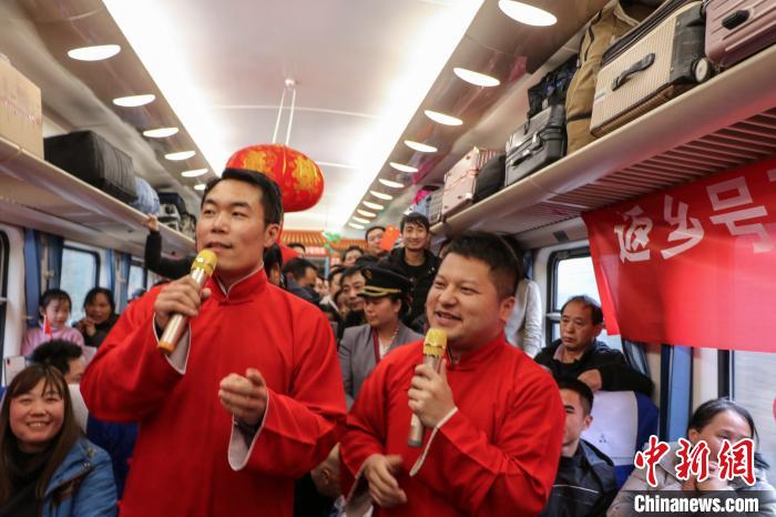 图为工作人员在列车上表演相声节目。　王东铃 摄